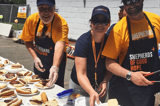Volunteers serving hotdogs at homeless shelter