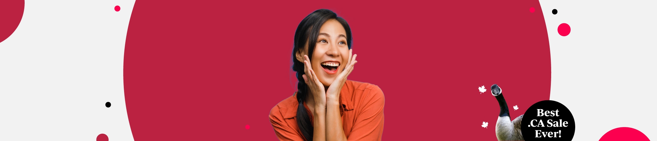 Girl in front of a red background, looking to the right and smiling with hands on he cheek