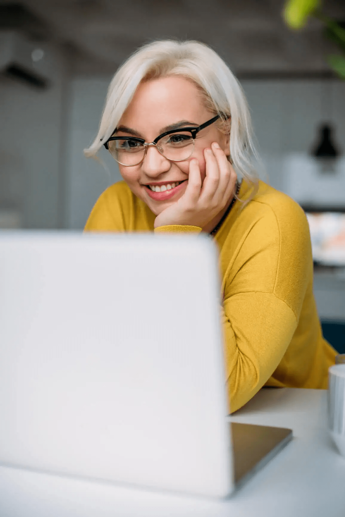 Woman smiling at computer screen
