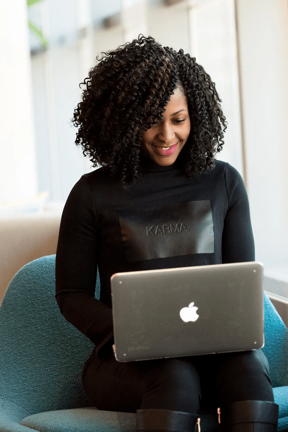 Woman smiling while typing on laptop