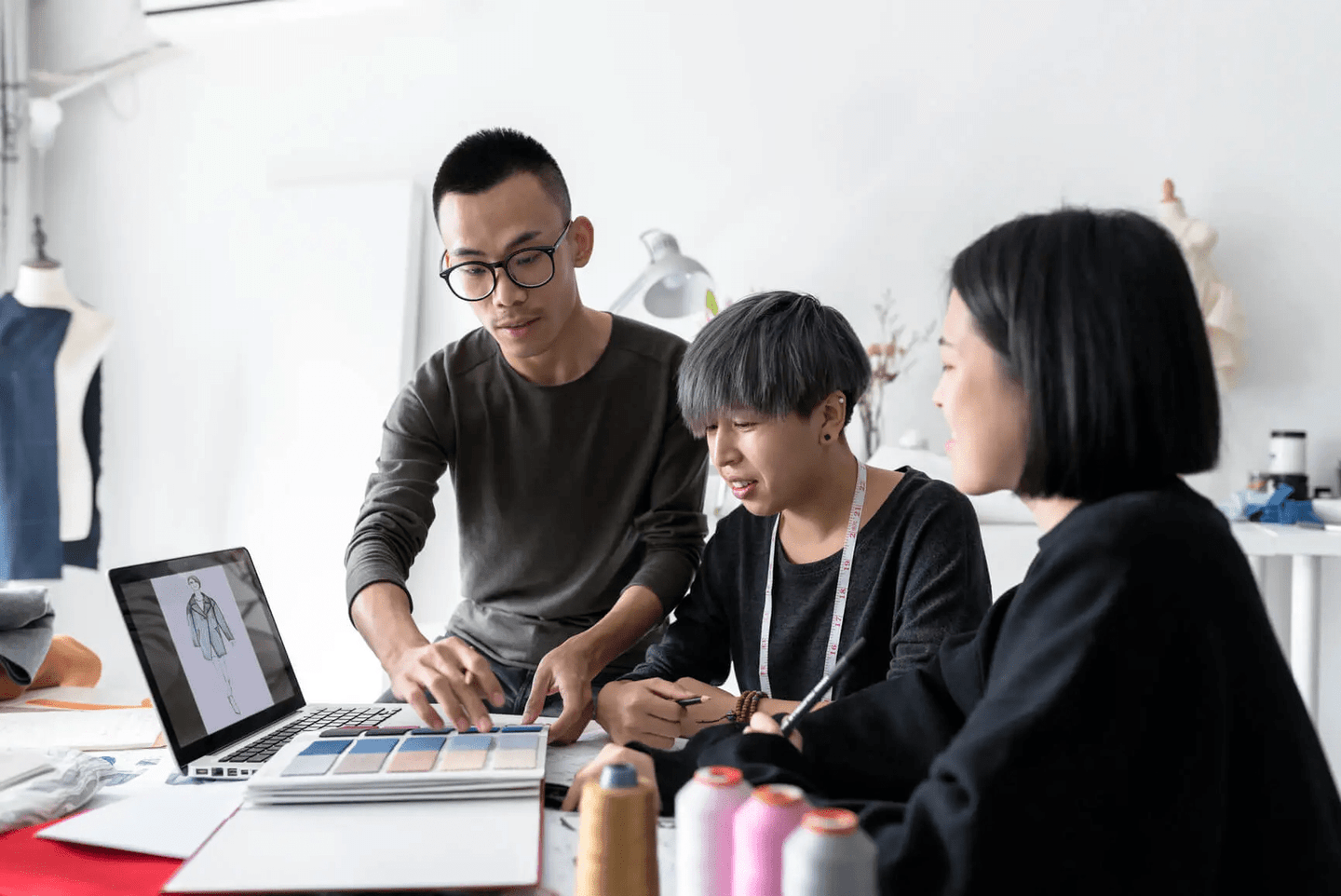 three people looking at laptop