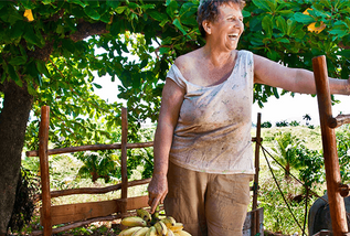 Woman volunteering and laughing while holding bananas