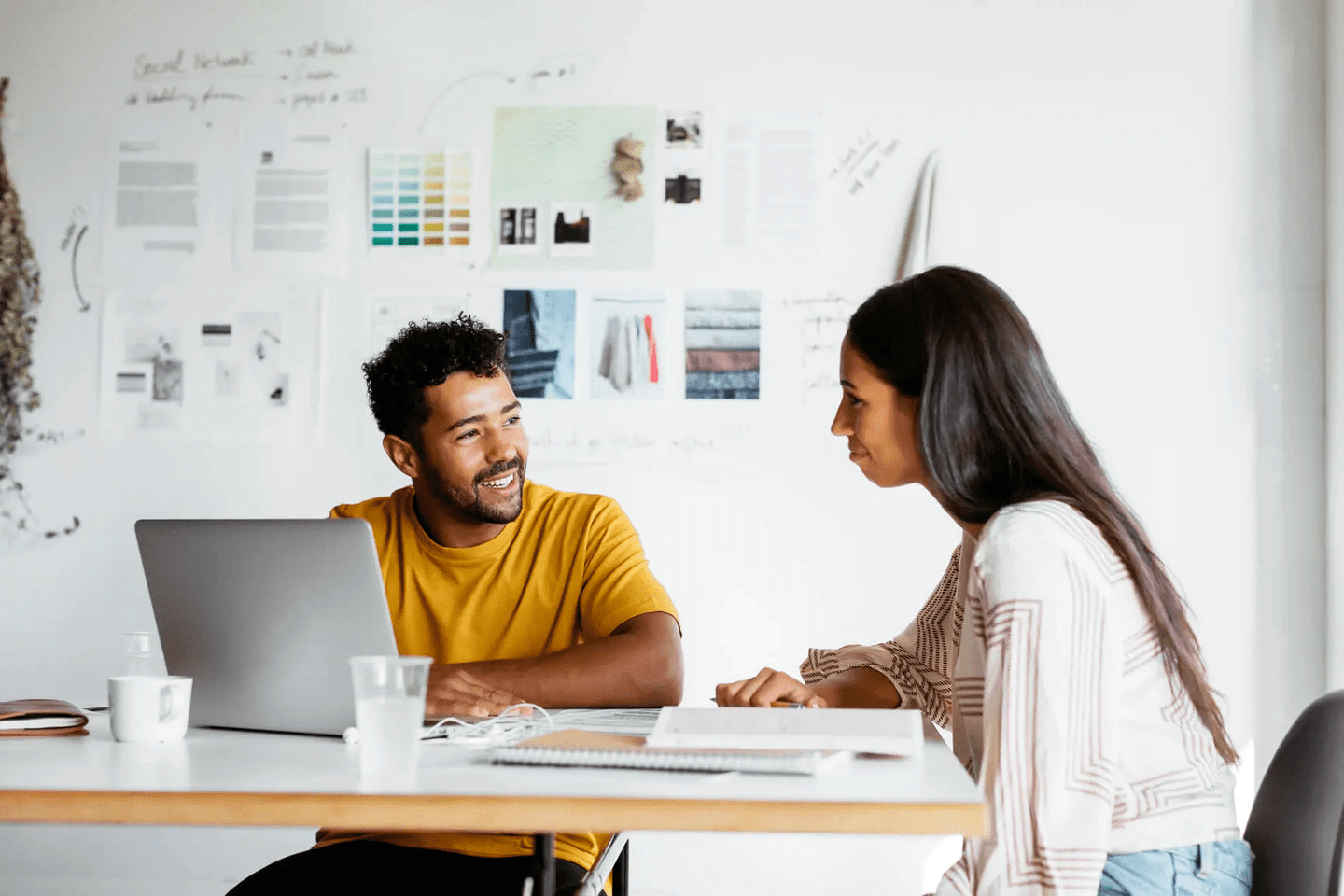 two people sitting around a laptop